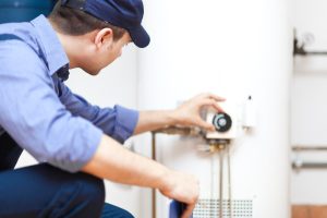technician tinkering with water heater